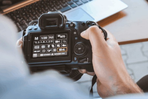 iemand die een camera vast houdt en hierbij de instellingen aan het veranderen is.